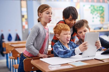 Photo for Selfies in class. elementary school children using a tablet in class - Royalty Free Image