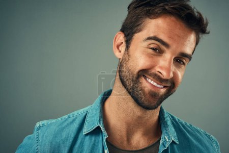 Photo for Hes an easygoing kinda guy. Studio portrait of a handsome young man posing against a grey background - Royalty Free Image