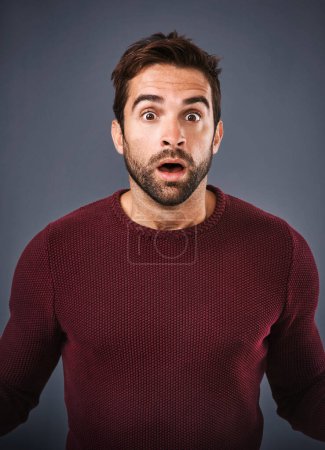 Photo for Oh. My. Word.Studio shot of a handsome young man looking surprised against a gray background - Royalty Free Image