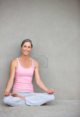 Téléchargez les photos : Écoute ton corps. une belle femme mature pratiquant le yoga en position lotus - en image libre de droit
