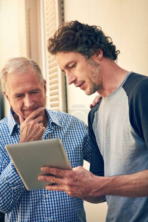 Photo for ... and thats all there is to it. a man showing his elderly father how to use a tablet at home - Royalty Free Image