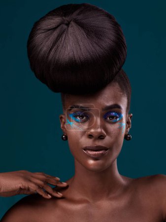 Foto de Retrato, cabello y maquillaje con una mujer africana en el estudio sobre un fondo azul para la belleza o la cosmética. Cara, cuidado del cabello y la moda con un atractivo modelo femenino joven en el salón de estilo de moda. - Imagen libre de derechos