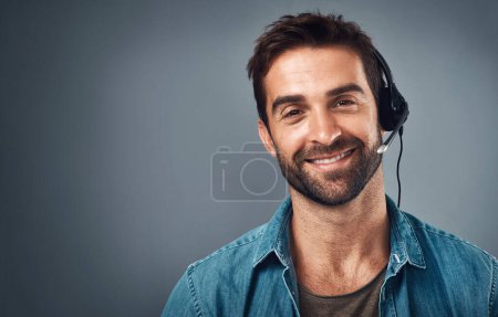 Photo for Happy man, call center and headphones for consulting on mockup space against a grey studio background. Portrait of friendly male consultant agent with smile and headset in contact us or online advice. - Royalty Free Image