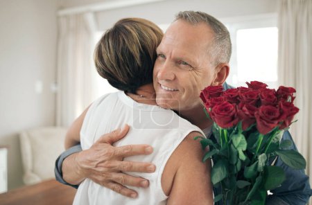 Téléchargez les photos : Juste pour te rappeler à quel point tu es spécial. un mari donnant des roses à sa femme - en image libre de droit