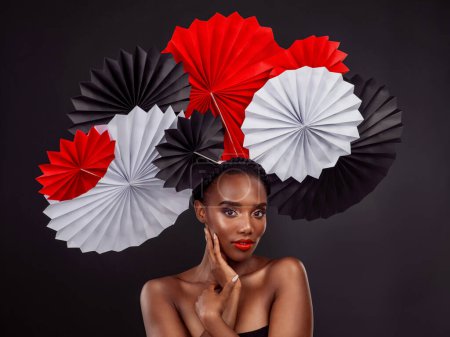 Photo for Beauty, portrait and black woman with origami fans in studio isolated on a dark background. Serious face, makeup cosmetics and skincare of female model with traditional Japanese paper art for culture. - Royalty Free Image