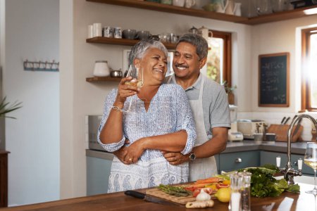Photo for Happiness, hug and old couple at kitchen counter with wine, food and cooking healthy dinner together. Smile, embrace and love, senior man and happy woman in retirement with drinks, vegetables and fun. - Royalty Free Image