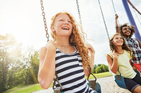 Foto de La mejor diversión al sol sucede en el parque. chicas jóvenes jugando en los columpios en el parque - Imagen libre de derechos