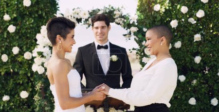 Photo for Love, holding hands and happy with lesbian couple at wedding for celebration, gay and pride. Smile, spring and happiness with women at marriage event for partner commitment, sexuality and freedom. - Royalty Free Image