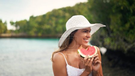 Photo for Woman, watermelon and holiday outdoor with a smile by the sea on a summer vacation. Happiness, female person and relax with fruit and healthy food in nature by the ocean with freedom and travel. - Royalty Free Image