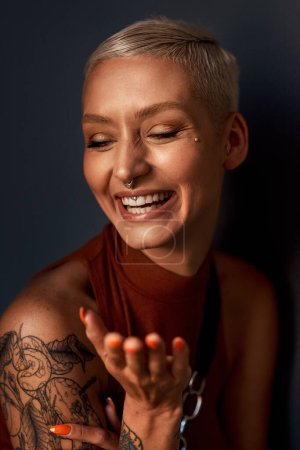 Photo for Young woman, happy laugh and tattoo with hipster and gen z fashion with a smile and piercing. Cool style, face and cosmetics of a female person with happiness, confidence and jewelry wearing makeup. - Royalty Free Image