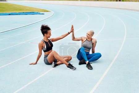 Photo for Woman, team and high five on stadium track for running, workout or exercise together for goal outdoors. Sports women touching hands for support, fitness or friends in motivation, teamwork or training. - Royalty Free Image