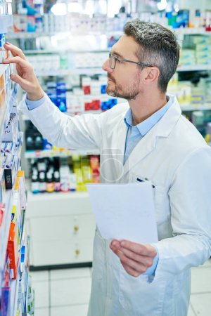 Photo for Filling the script to fit my clients pocket. a mature pharmacist working in a pharmacy - Royalty Free Image