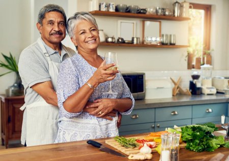 Téléchargez les photos : Portrait de vieux couple dans la cuisine avec vin, câlin et cuisine saine dîner aux légumes ensemble. Sourire, bonheur et nourriture, homme âgé et femme heureuse avec alcool, légumes et bien-être à la retraite - en image libre de droit