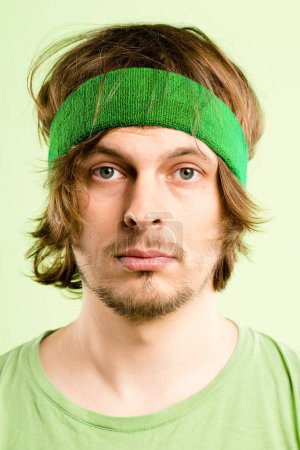 Photo for This green isnt motivating me at all. a handsome young man standing alone in the studio and posing while wearing a headband - Royalty Free Image