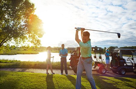 Photo for The perfect way to spend a sunny day. a man playing a round of golf with his friends - Royalty Free Image
