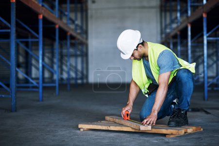 Photo for If its quality you want, its quality hell deliver. a young builder using a measuring tape at a construction site - Royalty Free Image
