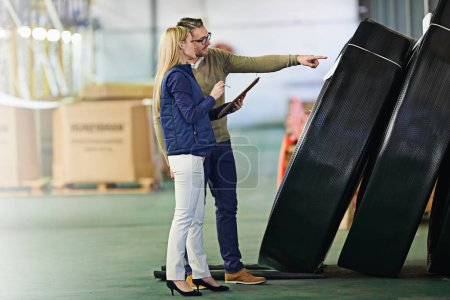 Photo for Checking output quality. a two managers examining product while standing on the warehouse floor - Royalty Free Image