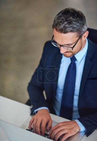 Photo for Hes quick to reply to his emails. a businessman using a laptop in the office - Royalty Free Image