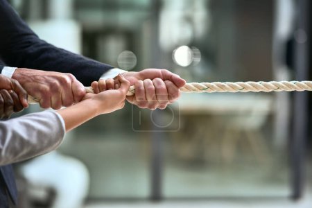 Photo for Hands, teamwork and rope with business people pulling during a game of tug of war in the office. Collaboration, help and strength with a team of employees or colleagues holding onto an opportunity. - Royalty Free Image