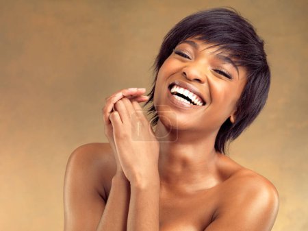 Téléchargez les photos : Beau rire. Plan studio d'une belle jeune femme riant sur fond marron - en image libre de droit