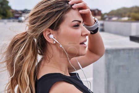 Foto de La música alimenta tanta energía en mí. una joven deportista escuchando música mientras hace ejercicio al aire libre - Imagen libre de derechos