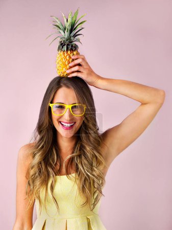 Photo for Keep your head up, before your crown falls. Studio shot of a young woman holding a pineapple against a pink background - Royalty Free Image