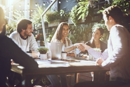Photo for To be the best, join with the best. colleagues shaking hands during a meeting at an outdoor cafe - Royalty Free Image