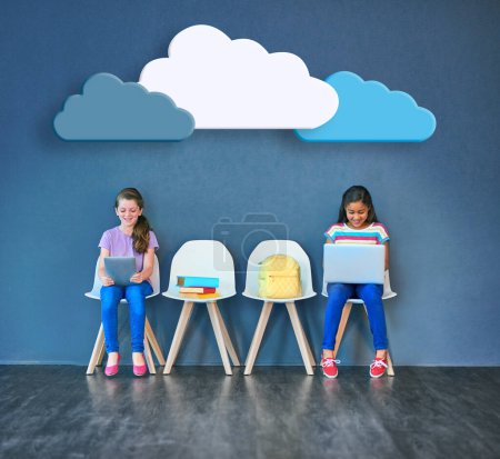 Photo for Supporting schoolwork with wireless technology. Studio shot of kids sitting on chairs and using wireless technology with clouds above them against a blue background - Royalty Free Image