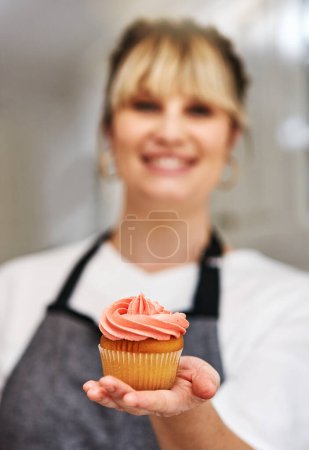 Téléchargez les photos : Les gens complimentent toujours mes friandises. une femme tenant un cupcake fraîchement cuit - en image libre de droit