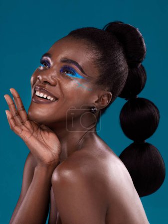 Photo for Thinking, happy and makeup with a model black woman in studio on a blue background for hair or cosmetics. Face, idea and fashion with an attractive young female person posing for cosmetic beauty. - Royalty Free Image