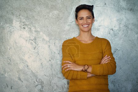 Téléchargez les photos : J'ai toute l'ambition de réussir gros. Portrait d'une jeune femme d'affaires confiante debout contre un mur gris - en image libre de droit