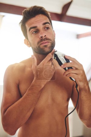 Photo for Man, shaving and face with electrical razor for hair removal, aesthetic skincare or beauty cleaning at home. Shirtless guy shave beard with blade, trimmer and cosmetic tool in bathroom in the morning. - Royalty Free Image