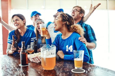 Photo for Sports, fun and friends. What more could you ask for. a group of friends cheering while watching a sports game at a bar - Royalty Free Image
