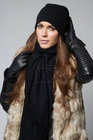 Photo for Woman, portrait and fashion in luxury for winter clothing, warmth and fur posing against a gray studio background. Attractive, gorgeous and young female person or model in pose in fashionable clothes. - Royalty Free Image