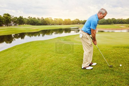 Photo for Focused on the shot at hand. a mature man out playing golf in his free time - Royalty Free Image