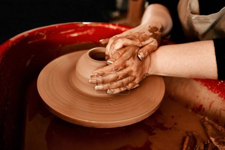 Photo for Embrace this earth. an unrecognizable woman molding clay on a pottery wheel - Royalty Free Image