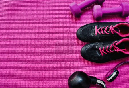 Photo for These are my essentials for a workout. High angle shot of a group of workout essentials lying on top of a pink background inside of a studio - Royalty Free Image
