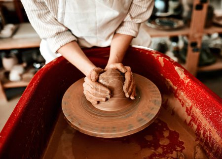 Foto de Convierto la arcilla en algo útil. una mujer irreconocible moldeando arcilla en una rueda de cerámica - Imagen libre de derechos