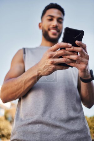 Photo for Fitness, sports and man with phone in hands, checking health app, social media or workout tracker online. Smile, wellness and male athlete with cellphone to check digital exercise schedule in park - Royalty Free Image