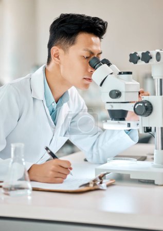 Foto de Ciencia, escritura y microscopio con un médico asiático que trabaja en un laboratorio para investigación o innovación. Cuidado de la salud, investigación y cuaderno con un científico masculino en un laboratorio para análisis médicos. - Imagen libre de derechos