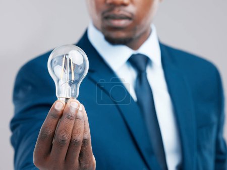 Photo for Energy, hand and businessman with light bulb for idea, knowledge or inspiration for corporate business strategy. Electricity, lightbulb and black man with creative solution, innovation or closeup. - Royalty Free Image