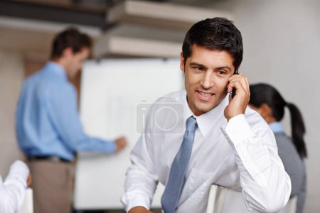 Foto de Te estoy diciendo que tenemos que vender. Un joven ejecutivo enojado recibiendo una llamada durante una presentación de negocios - Imagen libre de derechos