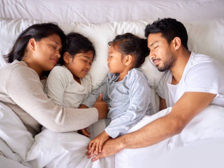 Téléchargez les photos : Détendez-vous, l'amour et la famille dormant dans un lit d'en haut, paisible et rêvant dans leur maison. Dormir, la paix et la vue sur le dessus des enfants avec les parents dans une chambre, fatigué et se reposant ensemble le week-end. - en image libre de droit