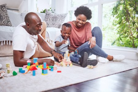 Photo for Toys, building blocks and black family playing on a living room floor happy, love and bonding in their home. Child development, learning and kid with parents in a lounge with alphabet, shape and game. - Royalty Free Image