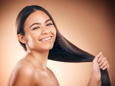 Photo for Woman, hair style and cosmetic in studio portrait for beauty, healthy shine and smile by brown background. Girl, youth model and haircare with cosmetics, hand and self care for aesthetic by backdrop. - Royalty Free Image