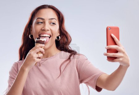 Photo for Woman, ice cream and selfie with smile in studio for summer vacation, social media app and blog by white background. Girl, gelato or dessert with photography, profile picture and happy by backdrop. - Royalty Free Image