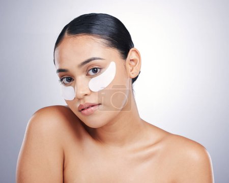 Photo for Face, eye mask and beauty of a woman in studio for glow, dermatology or natural cosmetics. Portrait of model person with collagen skincare patch for facial self care or wellness on a white background. - Royalty Free Image