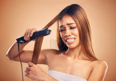 Photo for Woman with flat iron, haircare and heat damage, mistake and worried about hair loss on studio background. Electric straightener, female model with anxiety about keratin treatment fail and hairstyle. - Royalty Free Image