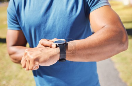 Photo for Fitness, stopwatch and man with a watch outdoor for training or running progress at park. Smartwatch on arm of athlete person in nature with time to exercise, start run and check performance goals. - Royalty Free Image