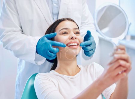 Dental consultation, mirror and woman with smile after teeth whitening, service or mouth care. Healthcare, dentistry and happy female patient with orthodontist for oral hygiene, wellness and cleaning.